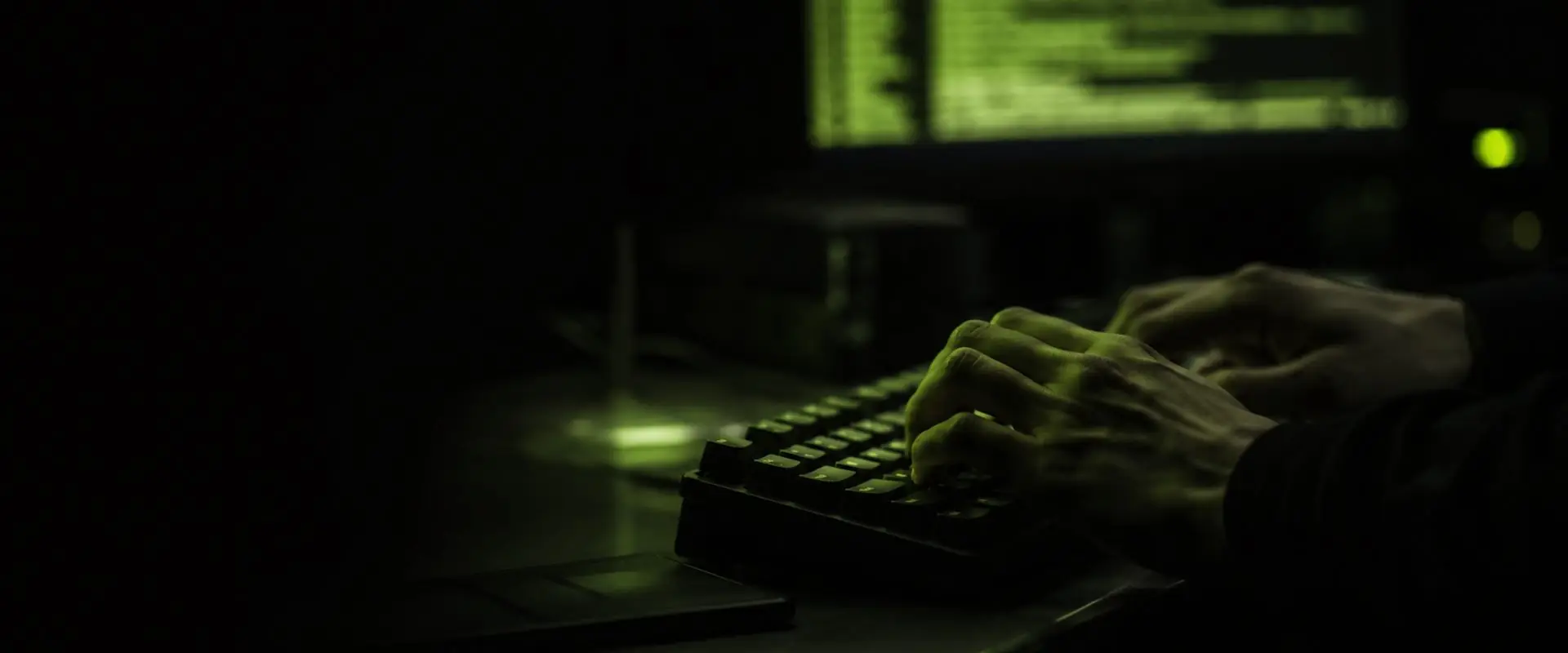 Penetration testing operator working at a red-lit keyboard